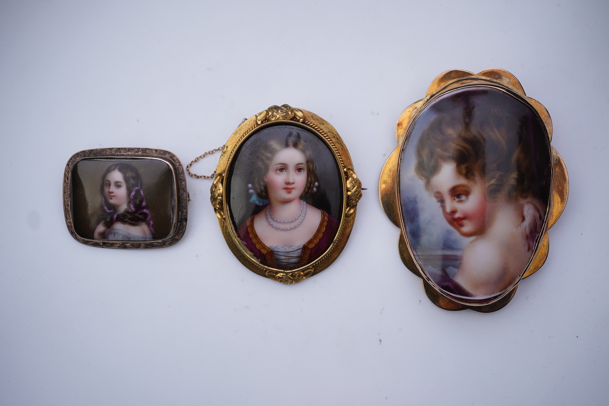 Three painted enamel brooches, mid 19th century